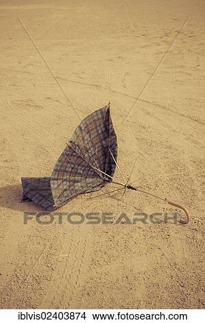 Broken umbrella lying on the ground View Large Photo Image Picture - Broken umbrella lying on the ground. Fotosearch