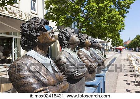Stock Image - Bronze figures, one wearing sunglasses, looking up, Balingen, Baden-Wuerttemberg, Germany, Europe, PublicGround, Europe. Fotosearch