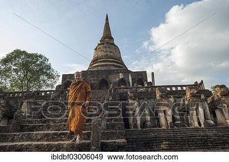 Stock Photo - "Buddhist monk on the stairs, laterite chedi with destroyed elephant statues, stepped temple of Wat Chang Lom, Si Satchanalai Historical Park, UNESCO World Heritage Site, Si Satchanalai, Sukhothai Province, Northern Thailand, Thailand, Asia". Fotosearch