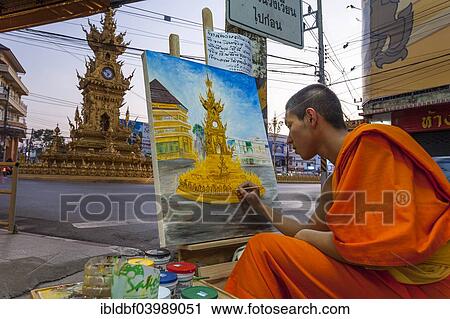 Stock Image - "Buddhist monk painting a clock tower, Wiang Mueang, Chiang Rai, Chiang Rai Province, Northern Thailand, Thailand, Asia". Fotosearch