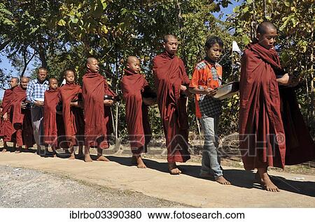 Stock Image - "Buddhist monks collecting alms, Full Moon Festival in December, Nyaung Shwe, Shan State, Myanmar, Burma, Asia". Fotosearch