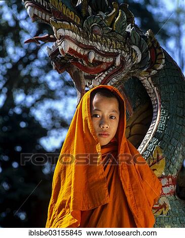 Stock Photography - "Buddhist novice in front of a Naga figure, Thailand, Asia". Fotosearch