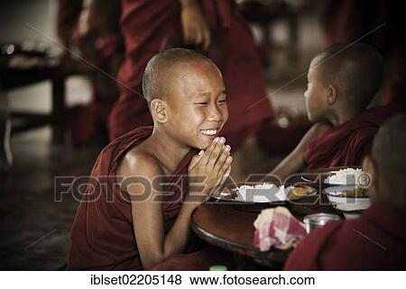 "Buddhist novice praying, sitting at a table, Bagan, Mandalay Division, Myanmar, Burma, Asia" View Large Photo Image Stock Photo - "Buddhist novice praying, sitting at a table, Bagan, Mandalay Division, Myanmar, Burma, Asia". Fotosearch
