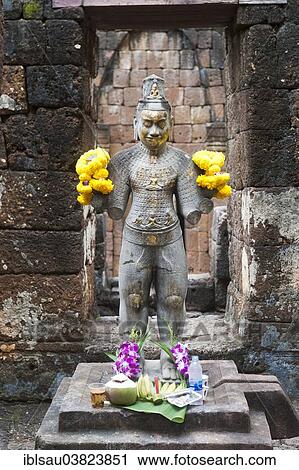Stock Image - "Buddhist statue of Bodhisattva Avalokiteshvara with offerings in the temple, historical settlement of the Khmer, Mueang Sing Historical Park, Amphoe Sai Yok, Kanchanaburi province, Central Thailand, Thailand, Asia". Fotosearch