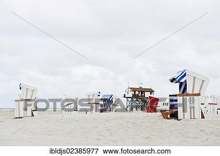 "Building on stilts and roofed wicker beach chairs on the beach of St. Peter-Ording, North Frisia, Schleswig-Holstein, Germany, Europe" View Large Photo Image Stock Photo - "Building on stilts and roofed wicker beach chairs on the beach of St. Peter-Ording, North Frisia, Schleswig-Holstein, Germany, Europe". Fotosearch