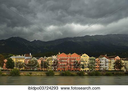Stock Image - "Buildings along the Inn river with dramatic clouds, Innsbruck, Tyrol, Austria, Europe". Fotosearch