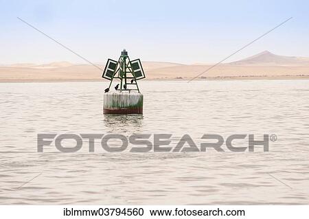 Stock Image - "Buoy, near Walvis Bay, Namib Desert at back, Namibia, Africa". Fotosearch