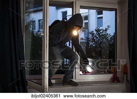 Burglar entering an apartment after having pryed open the window with a screwdriver View Large Photo Image Stock Image - Burglar entering an apartment after having pryed open the window with a screwdriver. Fotosearch