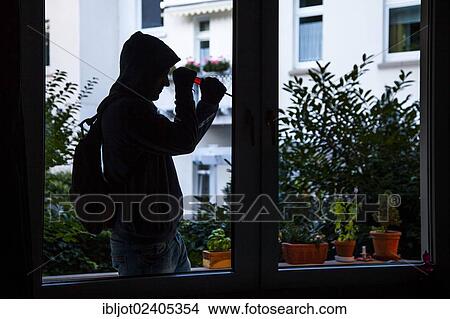 Burglar prying open a window with a screwdriver broad daylight View Large Photo Image Picture - Burglar prying open a window with a screwdriver broad daylight. Fotosearch