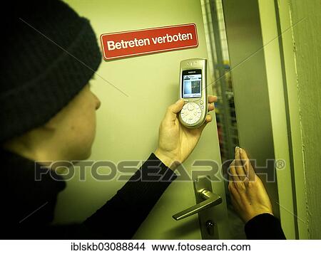 "Burglar using a camera phone to take a photograph through the gap of a door, symbolic image for industrial espionage" View Large Photo Image Picture - "Burglar using a camera phone to take a photograph through the gap of a door, symbolic image for industrial espionage". Fotosearch