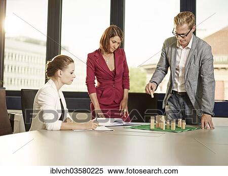 Stock Photography - "Business coach with clients using a system board, Innsbruck, Tyrol, Austria, Europe". Fotosearch