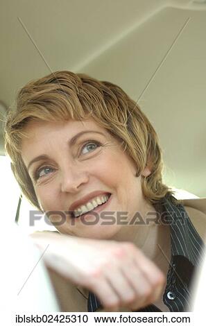 Stock Image - "Business woman in a car, portrait". Fotosearch
