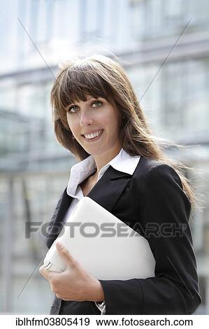 "Business woman with laptop under her arm, Lower Saxony, Germany, Europe" View Large Photo Image Stock Photo - "Business woman with laptop under her arm, Lower Saxony, Germany, Europe". Fotosearch