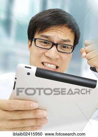 Businessman, Asian, with glasses, iPad, hand clenched in a fist, upset, angry, stressed out View Large Photo Image Stock Image - Businessman, Asian, with glasses, iPad, hand clenched in a fist, upset, angry, stressed out. Fotosearch