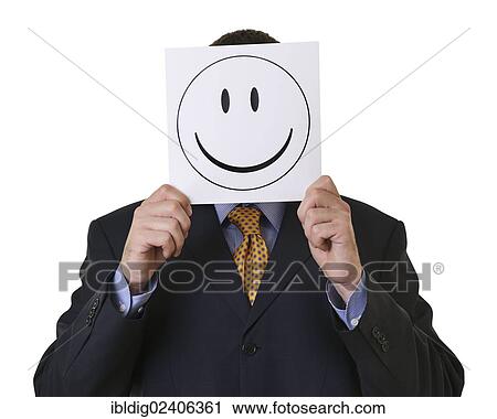 Stock Image - Businessman holding a smiley in front of his face. Fotosearch