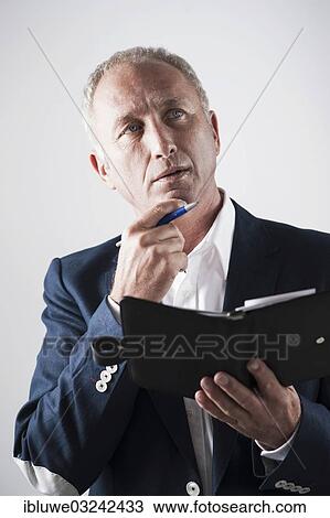 Stock Image - "Businessman holding an appointment calendar, Mannheim, Baden-Wurttemberg, Germany, Europe". Fotosearch