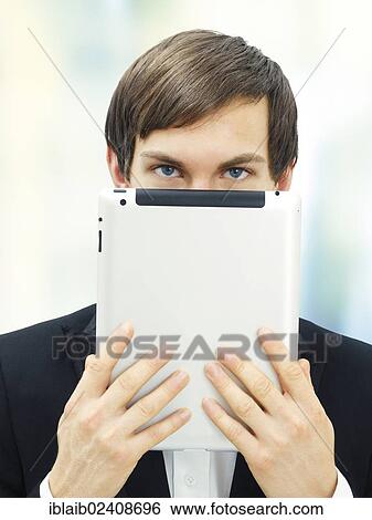 Stock Photograph - Businessman holding an iPad in front of his face. Fotosearch