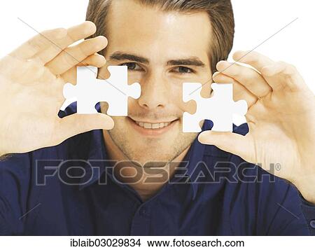 Businessman holding puzzle pieces View Large Photo Image Picture - Businessman holding puzzle pieces. Fotosearch