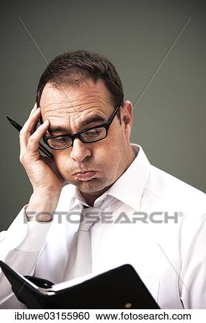 "Businessman wearing glasses looking at his appointment calendar, Mannheim, Baden-Wurttemberg, Germany, Europe" View Large Photo Image Stock Image - "Businessman wearing glasses looking at his appointment calendar, Mannheim, Baden-Wurttemberg, Germany, Europe". Fotosearch