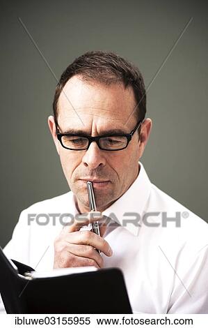 "Businessman wearing glasses looking at his appointment calendar, Mannheim, Baden-Wurttemberg, Germany, Europe" View Large Photo Image Stock Photography - "Businessman wearing glasses looking at his appointment calendar, Mannheim, Baden-Wurttemberg, Germany, Europe". Fotosearch