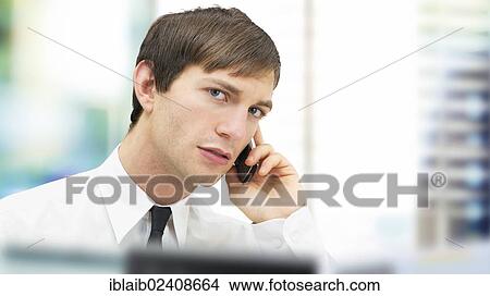 Picture - "Businessman with a serious face speaking on his mobile phone, portrait, focused". Fotosearch