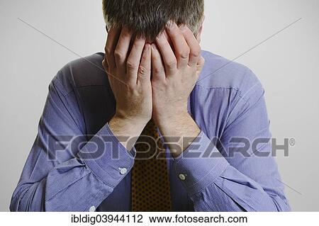 Stock Image - Businessman with his head in his hands. Fotosearch