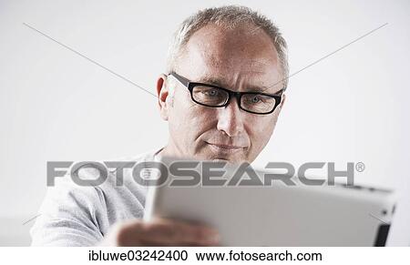 Stock Image - "Businessman working on a tablet PC, Mannheim, Baden-Wurttemberg, Germany, Europe". Fotosearch