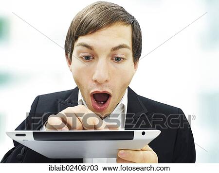 Stock Image - "Businessman working on an iPad, focused, amazed, surprised, portrait". Fotosearch
