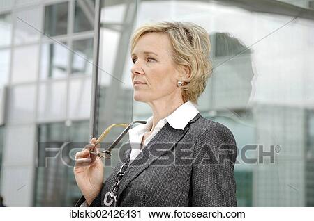 "Businesswoman, 40-50 years, standing next to a glass facade" View Large Photo Image Stock Image - "Businesswoman, 40-50 years, standing next to a glass facade". Fotosearch