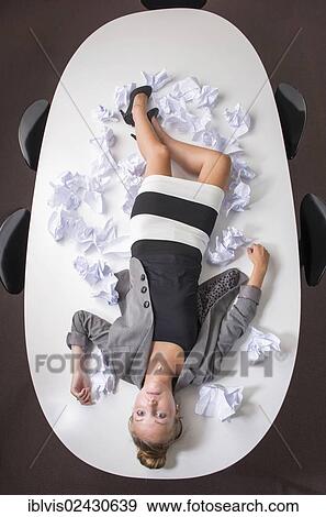 "Businesswoman having a break, lying on her desk, exhausted from stress in her workplace" View Large Photo Image Stock Photo - "Businesswoman having a break, lying on her desk, exhausted from stress in her workplace". Fotosearch