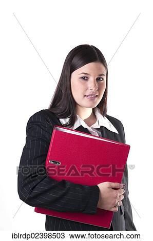 Stock Image - "Businesswoman holding a red folder in her arm, smiling". Fotosearch