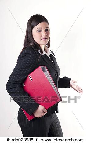 Businesswoman holding a red folder in her arm with a questioning attitude View Large Photo Image Stock Image - Businesswoman holding a red folder in her arm with a questioning attitude. Fotosearch