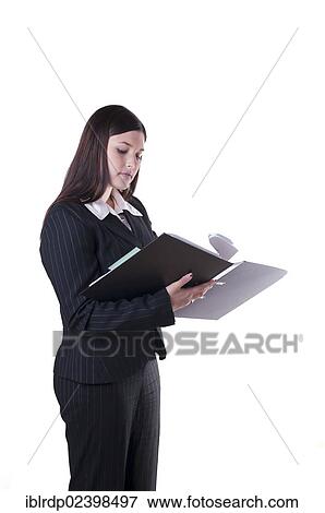 Stock Photo - Businesswoman reading and leafing through documents in a folder. Fotosearch