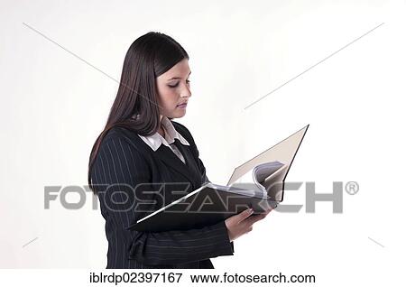 Businesswoman reading documents in a folder View Large Photo Image Stock Photo - Businesswoman reading documents in a folder. Fotosearch