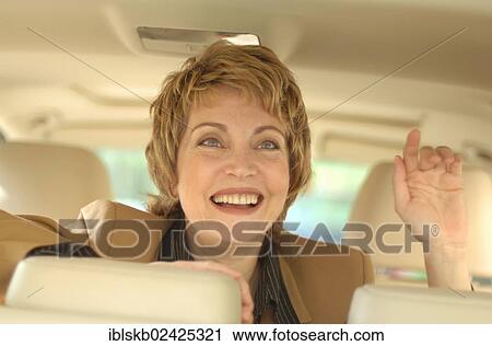 Stock Image - Businesswoman sitting in a car. Fotosearch