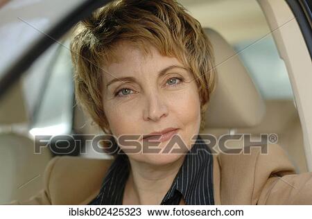 Stock Image - Businesswoman sitting in a car. Fotosearch