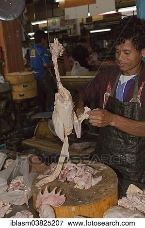 Stock Photo - "Butcher with a chicken on the market, Chiang Mai, Chiang Mai Province, Thailand, Asia". Fotosearch