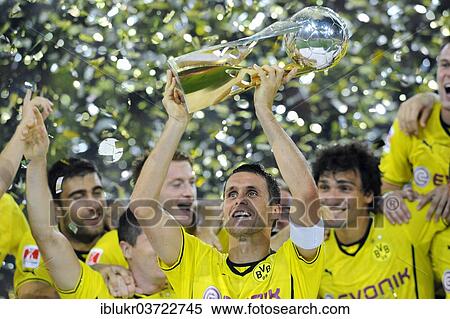 Stock Photography - "BVB players cheering, Sebastian Kehl with the Super Cup trophy in 2013, in front of Sokratis, Robert Lewandowski and Marco Reus, Signal Iduna Park, Dortmund, Ruhr district, North Rhine-Westphalia, Germany, Europe". Fotosearch