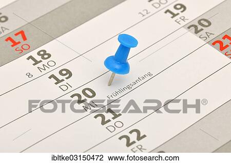 Stock Image - "Calendar with a push pin marking """"Fruehlingsanfang"""", German for the beginning of spring". Fotosearch