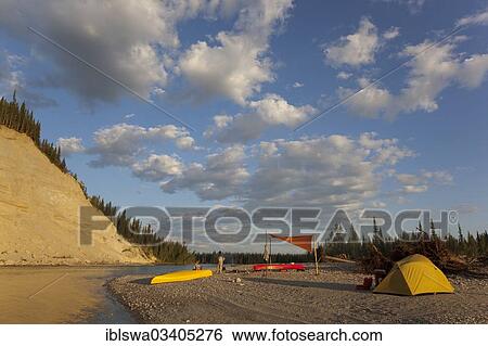 "camp with tent and tarp on a gravel bar, high cut bank behind, upper Liard river, Yukon Territory, Canada, North America" View Large Photo Image Stock Photograph - "camp with tent and tarp on a gravel bar, high cut bank behind, upper Liard river, Yukon Territory, Canada, North America". Fotosearch