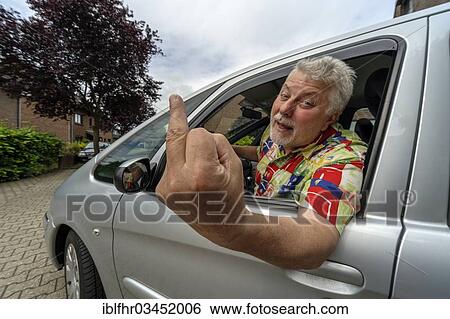 Stock Photograph - "Car driver giving the finger, Grevenbroich, Rhineland, North Rhine-Westphalia, Germany, Europe". Fotosearch