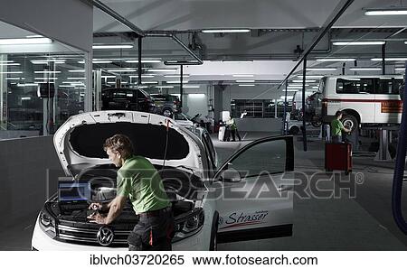 "Car mechanic running fault diagnostics on a laptop, VW Strasser, Volkswagen car repair shop, St. Gertraudi, Reith im Alpbachtal, Kufstein District, North Tirol, Tirol, Austria, Europe" View Large Photo Image Stock Photography - "Car mechanic running fault diagnostics on a laptop, VW Strasser, Volkswagen car repair shop, St. Gertraudi, Reith im Alpbachtal, Kufstein District, North Tirol, Tirol, Austria, Europe". Fotosearch