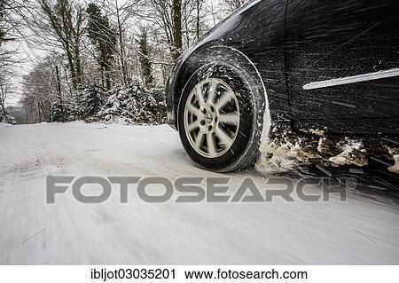 Car with winter tyres driving on a road covered with snow View Large Photo Image Stock Image - Car with winter tyres driving on a road covered with snow. Fotosearch