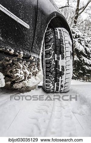 Car with winter tyres parked on a road covered with snow View Large Photo Image Stock Photo - Car with winter tyres parked on a road covered with snow. Fotosearch
