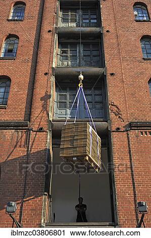Stock Image - "Cardboard boxes are lifted into storage, storehouse in the Speicherstadt historic warehouse district, Hamburg, Germany, Europe". Fotosearch