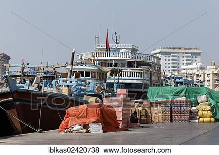 Cargo in front of an old wooden cargo ship, dhow or dau on Dubai Creek, Dubai, United Arab Emirates, Middle East, Asia View Large Photo Image Stock Photo - Cargo in front of an old wooden cargo ship, dhow or dau on Dubai Creek, Dubai, United Arab Emirates, Middle East, Asia. Fotosearch