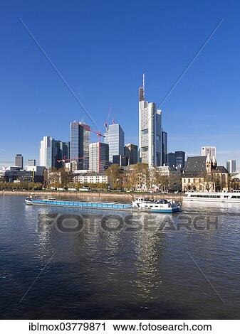 "Cargo ship on the Main river in front of the skyline of Frankfurt with the buildings of Opernturm, Frankfurt Cathedral, Deutsche Bank, Hessische Landesbank, Commerzbank, TaunusTurm, ECB, Frankfurt am Main, Hesse, Germany, Europe" View Large Photo Image Stock Image - "Cargo ship on the Main river in front of the skyline of Frankfurt with the buildings of Opernturm, Frankfurt Cathedral, Deutsche Bank, Hessische Landesbank, Commerzbank, TaunusTurm, ECB, Frankfurt am Main, Hesse, Germany, Europe". Fotosearch