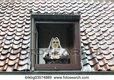 Stock Photo - "Caricature of a nun in a window, Bruges, West Flanders, Flemish Region, Belgium, Europe". Fotosearch