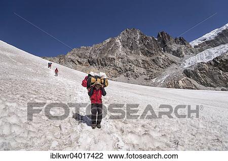Stock Image - "Carrier descending from the Cho La pass over snow field, Khumbu, Solukhumbu District, Mount Everest Region, Nepal, Asia". Fotosearch