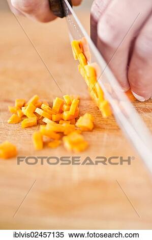 Carrots being chopped on a wooden cutting board View Large Photo Image Stock Photography - Carrots being chopped on a wooden cutting board. Fotosearch